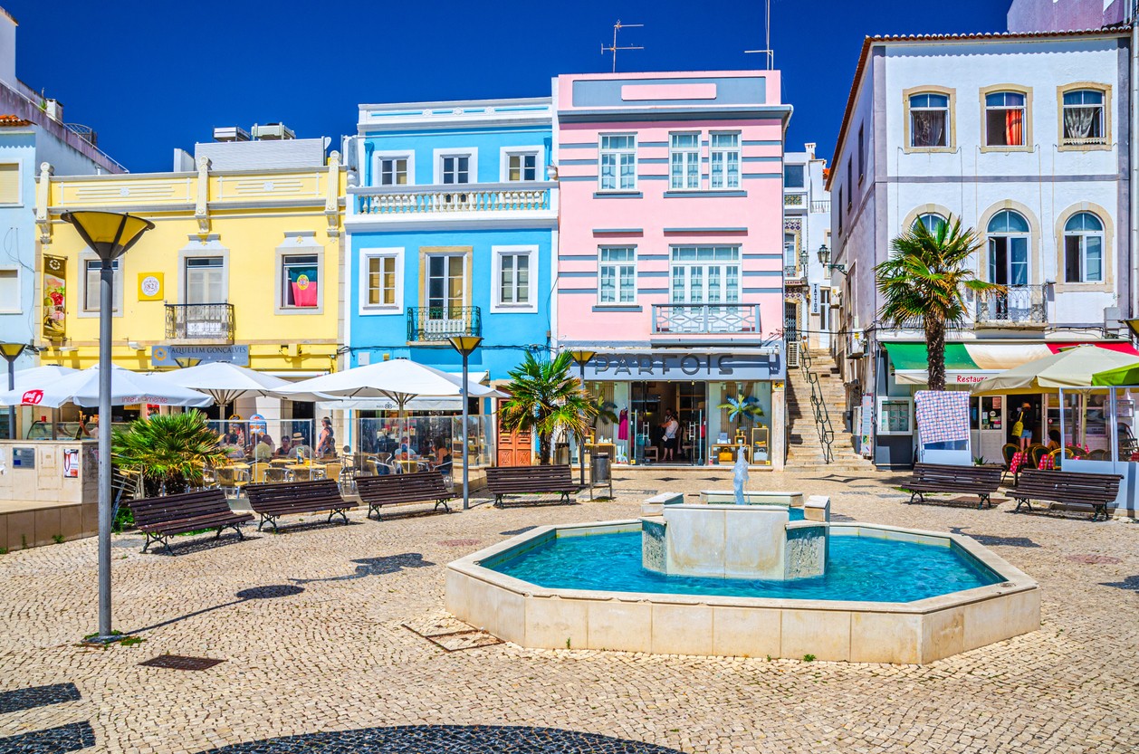 Lagos historical town centre with colorful multicolored buildings houses, fountain and benches in sunny summer day