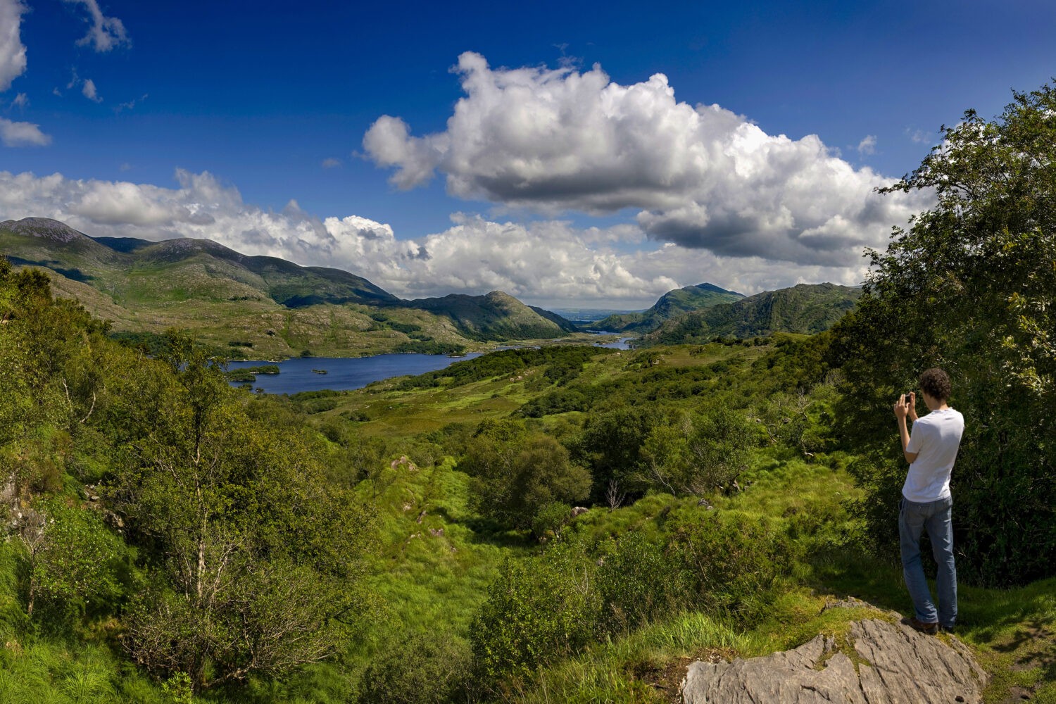A young man takes a photograph at Ladies View, Killarney, Co Kerry, Ireland